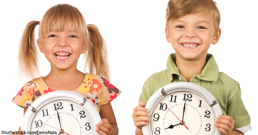 zwei Kinder haltene zwei große Uhren