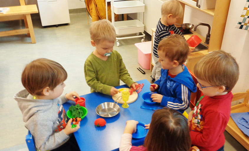 Kinder beim Spielen mit Plastik Geschirr