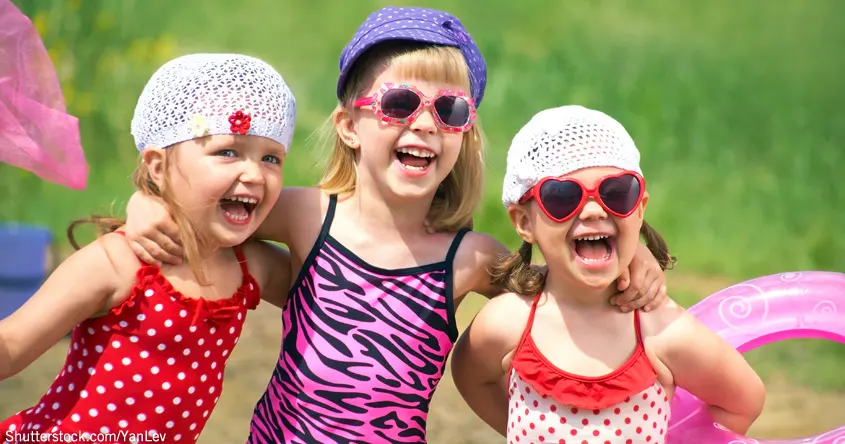 Kinder mit Sonnenbrillen und Badeanzügen lachen