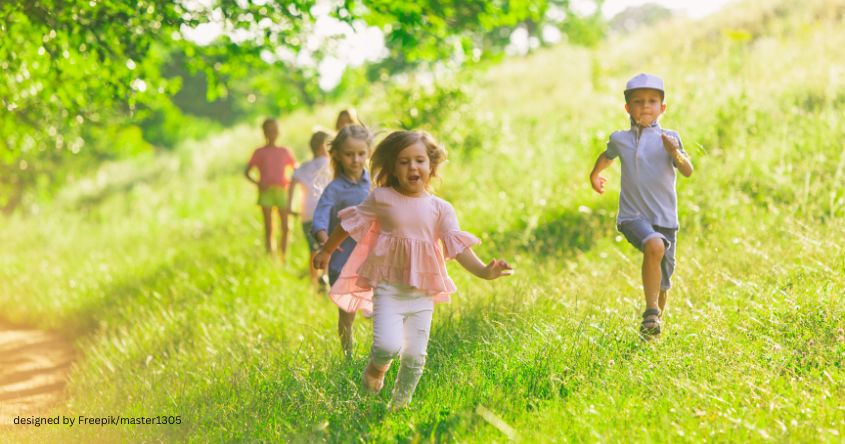 Kinder laufen über eine Wiese