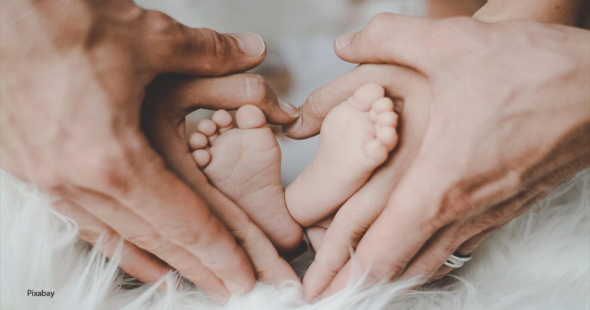 Babyfüße mit Hände von Mama und Papa