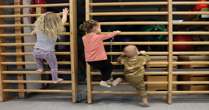 Kleinkinder klettern an der Sprossenwand