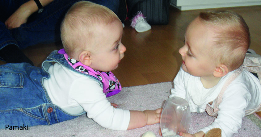 2 Babys am Boden liegend und Bälle