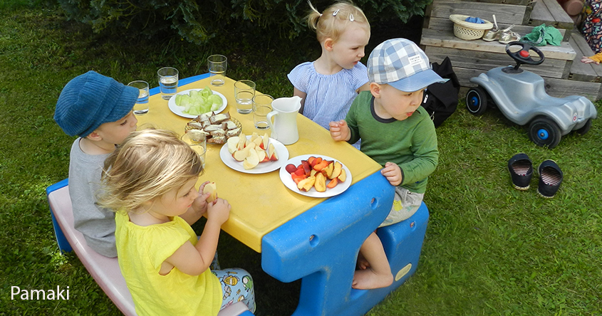 Kinder beim der Jause am Tisch