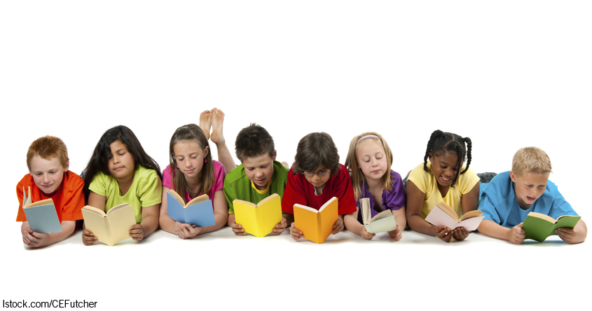 Kinder liegen am Boden und lesen