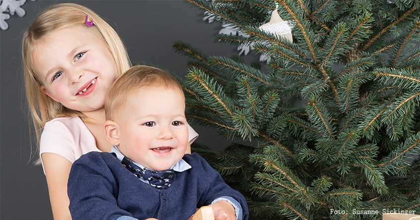2 Kinder vor Weihnachtsdeko