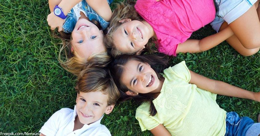 Kinder liegend in der Wiese