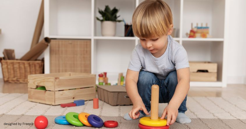 Bub spielt mit Holzspielsachen
