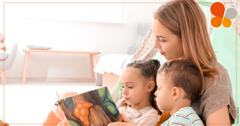 Frau lest zwei Kindern ein Buch vor