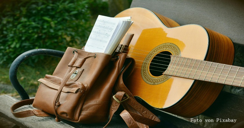 Gitarre und Rucksack mit Noten
