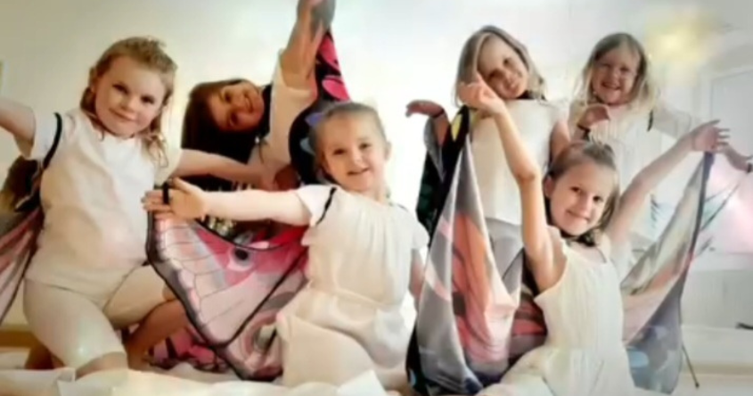 Kinder die mit Schmetterlingsflügeln tanzen