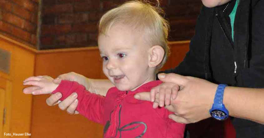 Kind geht an der Hand über Langbank