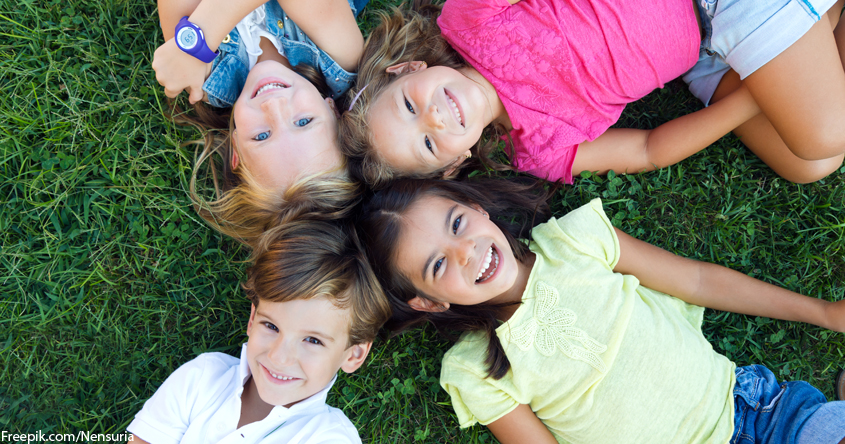 Kinder liegend in der Wiese